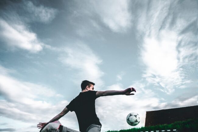 man playing soccer during daytime