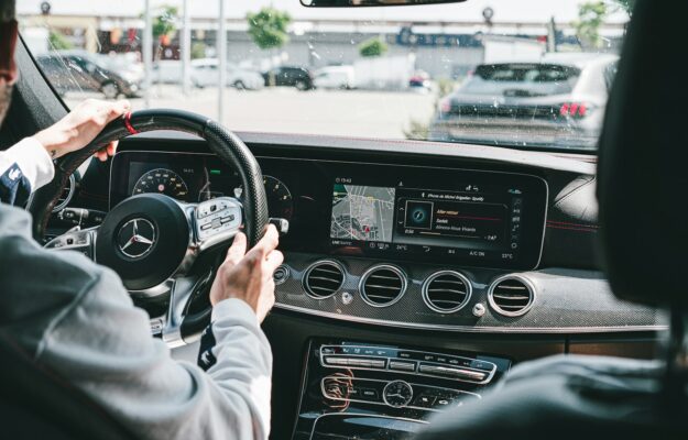 person in gray long sleeve shirt driving car
